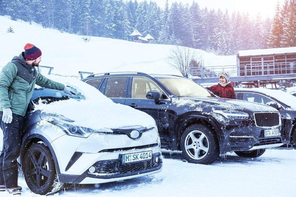 terwijl de auto in de winter opwarmt, kan hij worden ontdaan van sneeuw