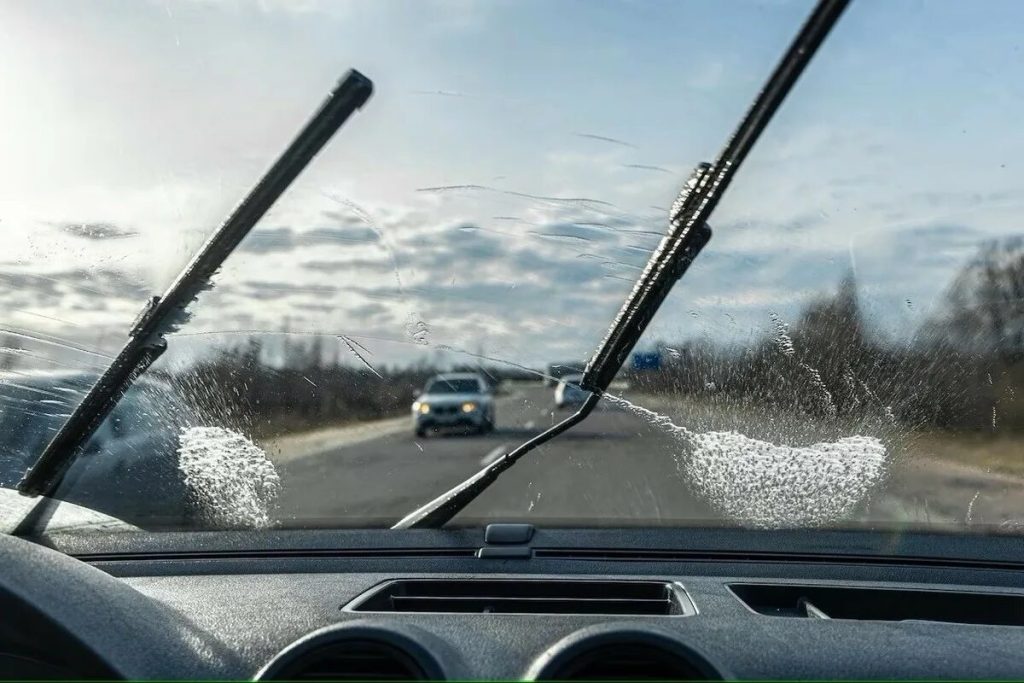 De ruitenwissers van de auto laten strepen achter op het glas