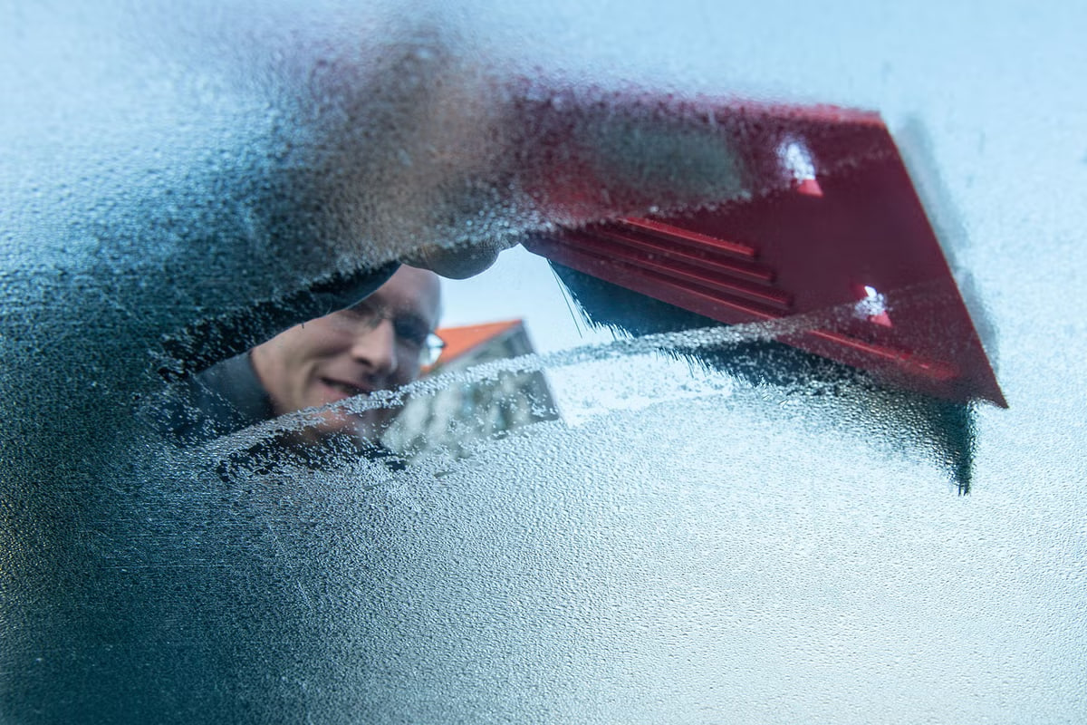 veegt het ijs van de voorruit van de auto