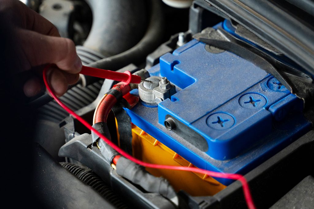 De man sloot de accu aan op de auto.