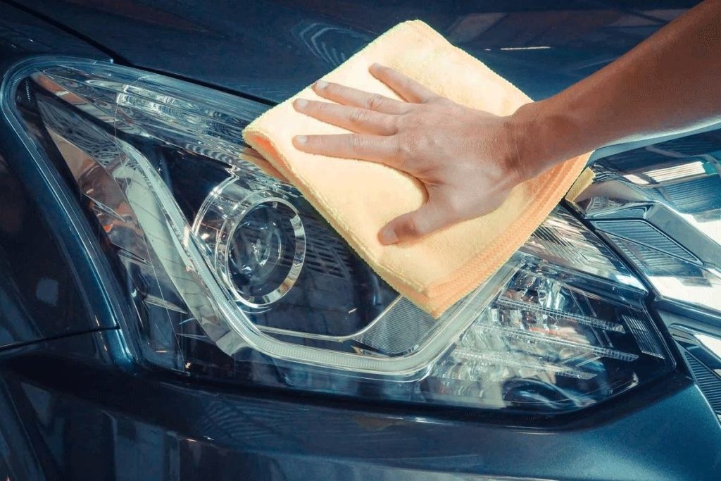 wrijven de koplampen af met een doekje